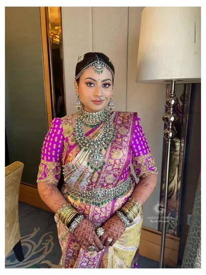 A duplicate of image 326, showing Nidhi's complete bridal look. The heavy silk saree and ornate jewelry are balanced with makeup that is both glamorous and elegant.