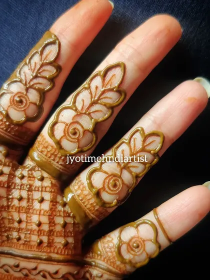 Another view of the floral cut-work on fingers, showing the consistency and precision of the design.