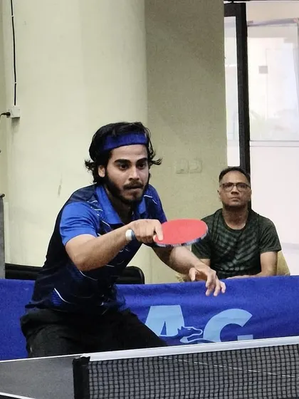 An athlete in the zone, preparing to return a serve during a competitive match. The mental aspect of the game is as important as the physical, and we train our players to be strategic thinkers.