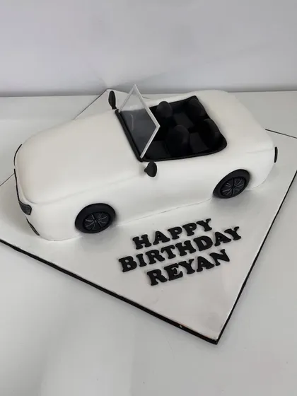A top-down view of the white convertible cake, showing the detailed interior seats.
