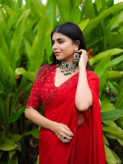 A beautiful medium shot focusing on the bride's expression and her stunning emerald jewelry set. The details are sharp and eye-catching.