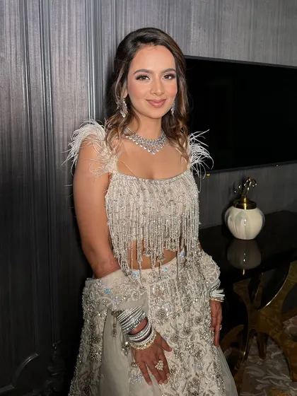 The sister-in-law looking absolutely radiant in a white and silver outfit. Her soft glam makeup and elegant hairstyle are perfect for a wedding reception.