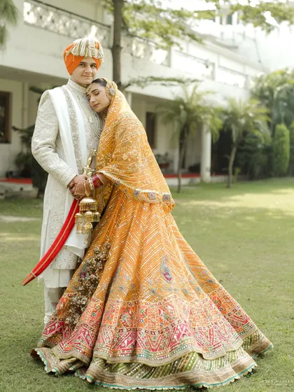 A portrait of regal elegance. The bride's stunning lehenga and the groom's classic sherwani create a timeless and graceful image.