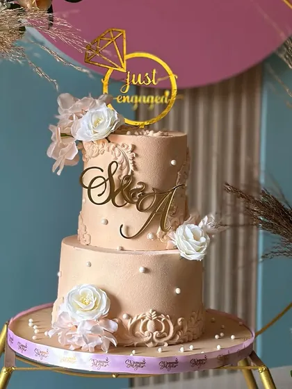 Soft, elegant, and timeless. This peach and white engagement cake, set within a beautiful floral hoop, combines graceful design with sweet simplicity, perfect for celebrating a new chapter.