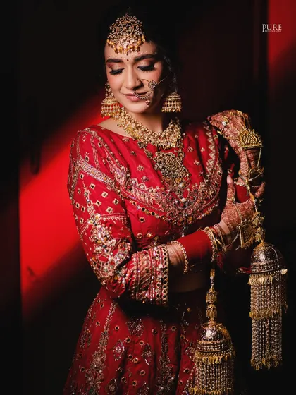 The bride looking down at her kaleere, a symbol of blessings from her family. This shot is full of tradition and emotion.
