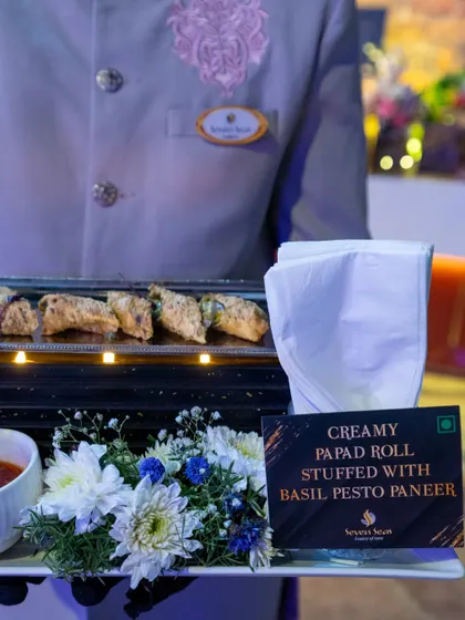A server presents our Creamy Papad Rolls, stuffed with basil pesto paneer. This dish is a perfect example of our progressive Indian cuisine, fusing traditional textures with contemporary global flavours.
