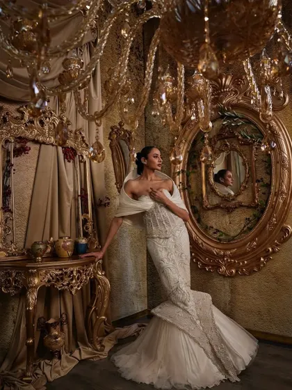 In this ivory gown, I explored the contrast between a corseted, fit-and-flare silhouette and the soft power of a dramatic hooded panel. The hand embellishments are meticulously placed to catch the light, creating a piece that feels both intentional and unforgettable, perfect for a modern bride.