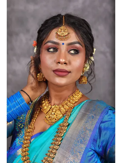 A thoughtful and elegant portrait, with the subject looking to the side, showcasing the beautiful details of her traditional attire.