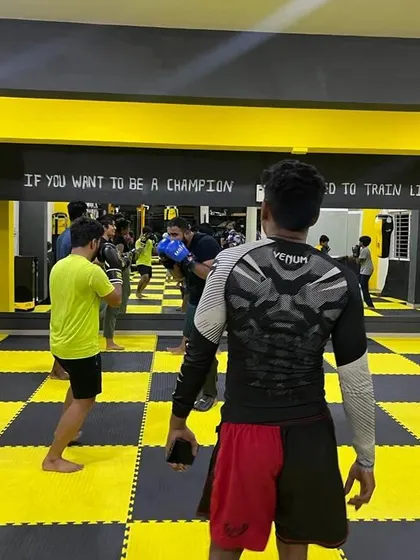 A look at a kickboxing class in session. The mirror helps students check their form while they practice. The quote on the wall says it all: "If you want to be a champion, you need to train like one."
