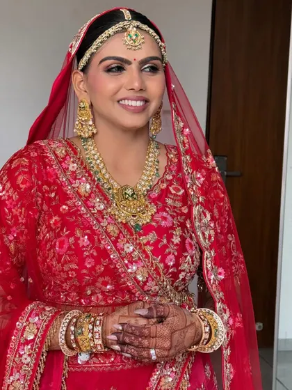 This bride chose a sleek and clean bun for her Pheras. The simplicity of the hairstyle allows her stunning red lehenga and traditional jewellery to take center stage.