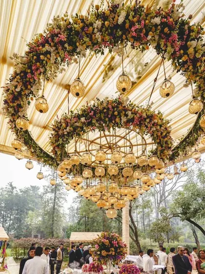 A magnificent floral chandelier created for an English day wedding. This double-ring of fresh flowers served as a stunning centerpiece for the outdoor tented reception.