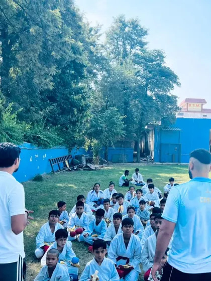 A different angle of the coaches speaking to the students, emphasizing the Gurukul style of teaching.