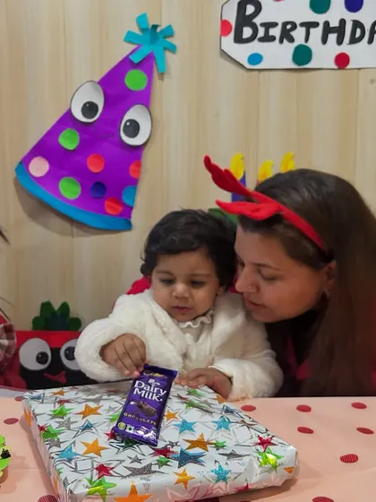 The birthday girl looks at her present with her mother, a special moment from her in-class celebration.
