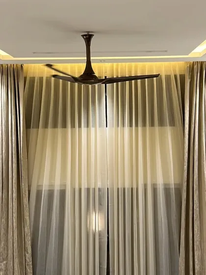 A view of a completed double-height curtain installation. The automated system ensures the curtains hang perfectly and operate flawlessly, adding a touch of elegance and modern functionality to the bedroom.