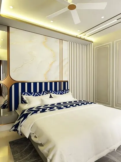 This bedroom retreat combines modern comfort with timeless style. The headboard has a striking blue and white striped pattern, and the wall behind it features a combination of marble and fluted panels.