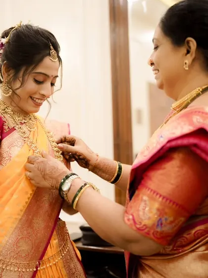 A mother helping her daughter get ready. The bride's makeup is complete, and she looks radiant and ready for her big day.