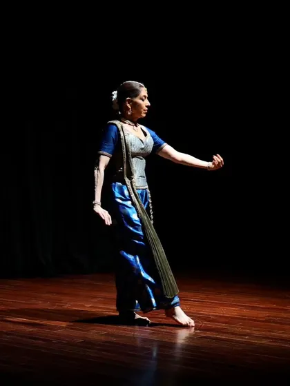 A dancer strikes a pose, her form illuminated by a single spotlight.