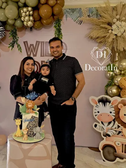 A happy family poses for a photo at their son's "Wild One" first birthday party.