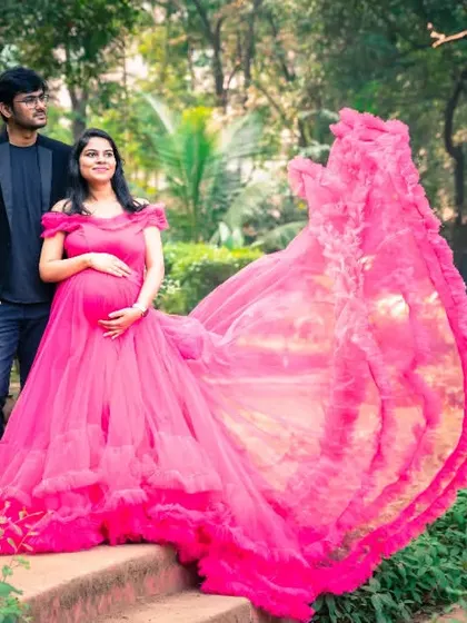 This magnificent pink ruffled gown is the star of the show. It creates a high-fashion, artistic look for a maternity shoot that is truly one of a kind.