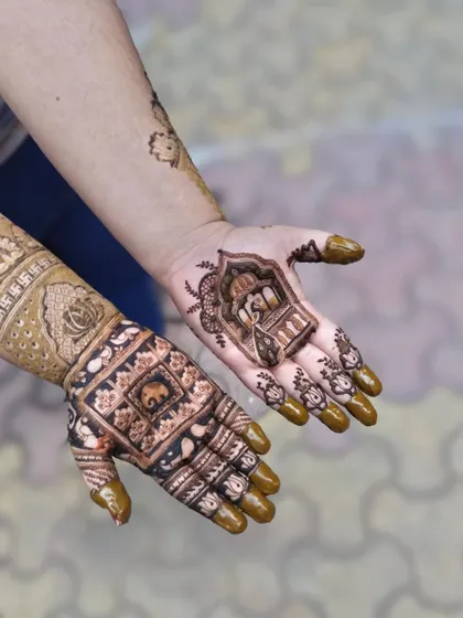 A mix of different designs on two hands, one with a palace and the other with an elephant. This shows how we can play with different elements.
