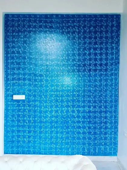 A geometric pattern applied to a blue accent wall. This textured finish catches the light differently throughout the day, adding subtle complexity to the room.