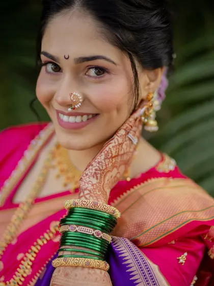 A close-up portrait highlighting the flawless makeup, Chandrakor bindi, and Nath.