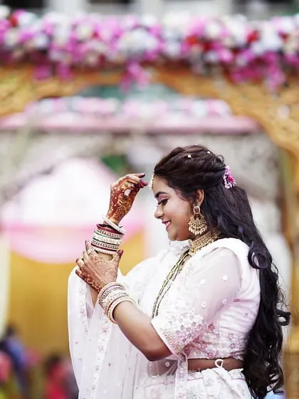 A lovely shot of the bride, showcasing her elegant hairstyle and soft makeup. This look is perfect for a daytime wedding or engagement ceremony.