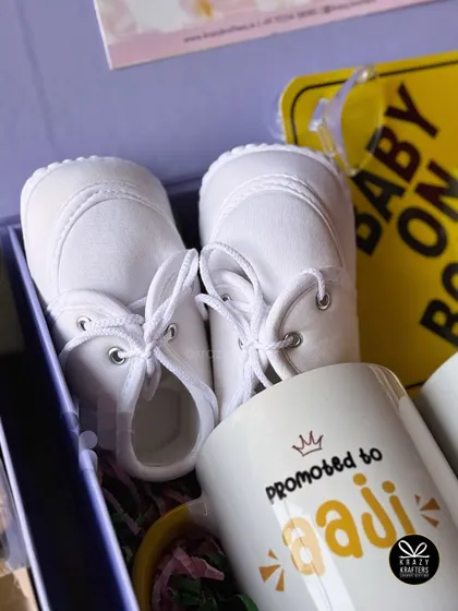 A detailed shot focusing on the tiny white baby shoes, a classic and heartwarming symbol of a new life on the way.