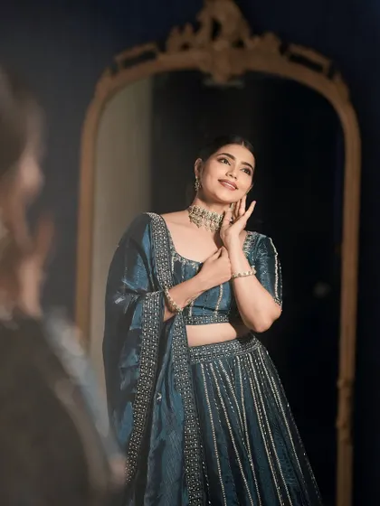 A mirror shot that captures the bride's happy expression. The makeup is designed to make her feel confident and beautiful.