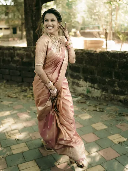 A happy bride takes a stroll, her pink saree glowing in the natural light.