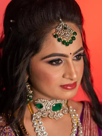 A dramatic and glamorous reception look for my sister Sushma. The bold, winged eyeliner and shimmery eyeshadow are paired with a statement emerald and diamond jewellery set.