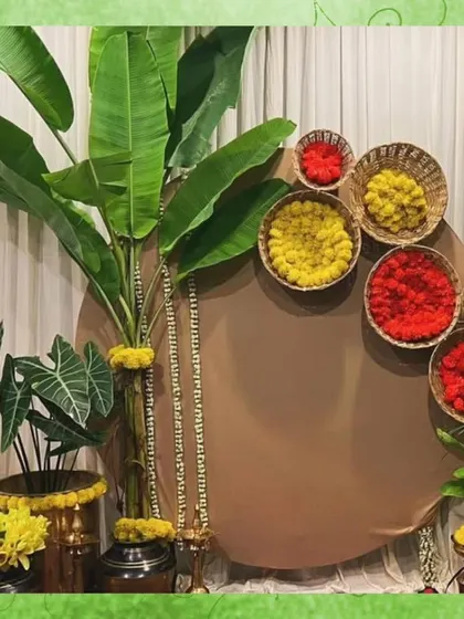 For a South Indian themed photobooth, I used a backdrop of banana leaves and baskets of red and yellow flowers. This design is a beautiful nod to tradition and creates a vibrant photo opportunity.