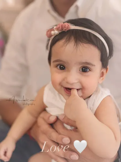 A close-up of a smiling baby girl, the very picture of love. These simple, expressive shots are often the most powerful.