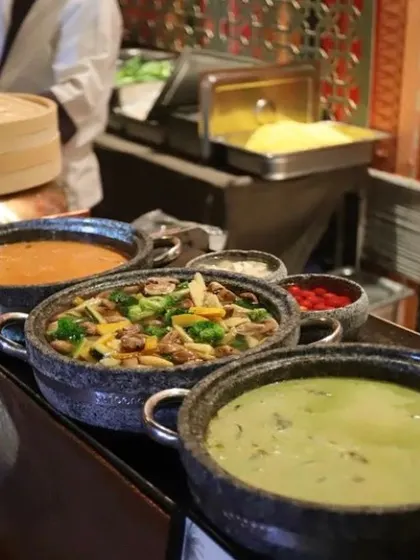 A selection of my Pan Asian main courses, including a vegetable stir fry and Thai green curry, ready to be served from stone bowls at a live buffet.