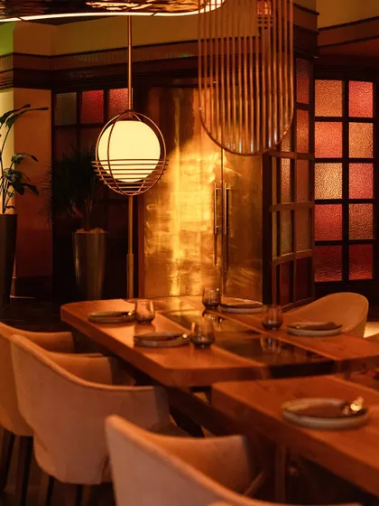 The interplay of light and texture is central to our design. Golden light reflects off metallic surfaces, creating a warm, inviting glow throughout the restaurant.