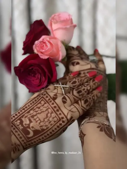An artistic shot of a back-hand design with swan motifs, held with roses.