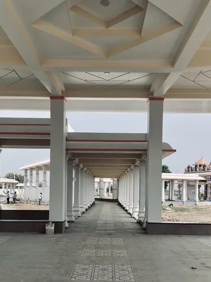 A view through one of the completed corridors at the Shiva Temple. The repetition of columns and the patterned flooring create a rhythmic and meditative pathway.