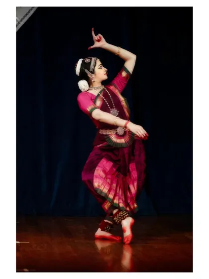 A dynamic pose with one leg extended, pointing upwards, showcasing flexibility and strength.