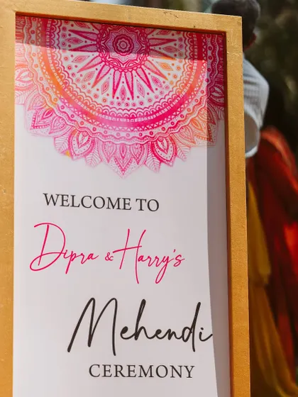 A stylish welcome sign for a Mehendi ceremony. The vibrant pink mandala design and modern fonts immediately signal a fun and festive event ahead.