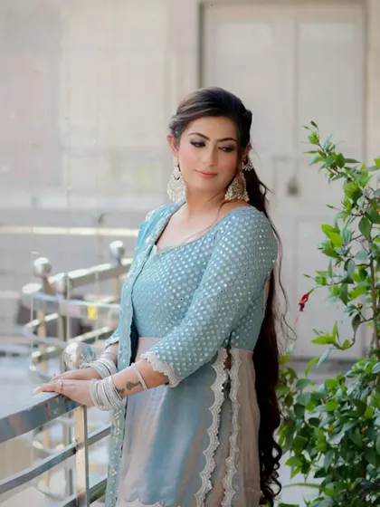 A beautiful outdoor portrait of bride-to-be Mannat in a lovely blue sharara set, looking serene and happy.