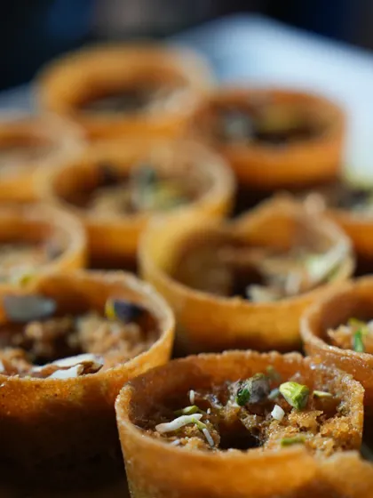 A close-up of our Ghevar tarts, a modern take on a classic dessert, filled with nuts and cream.