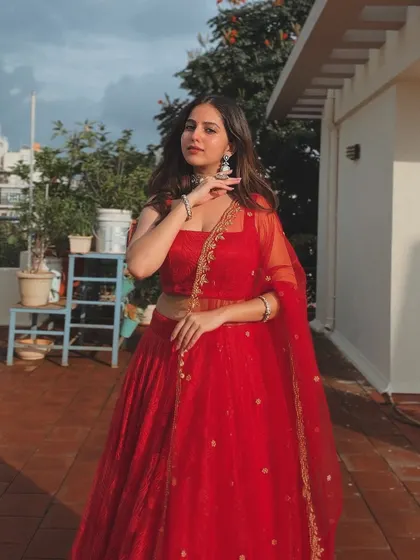 A full-length view of the red lehenga, showing its beautiful flare.