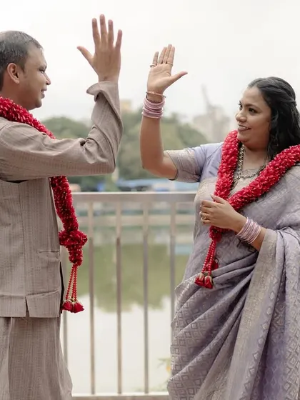 A celebratory high-five between the newlyweds. This fun, spontaneous gesture perfectly captures the feeling of "we did it!" and the partnership at the heart of their marriage.