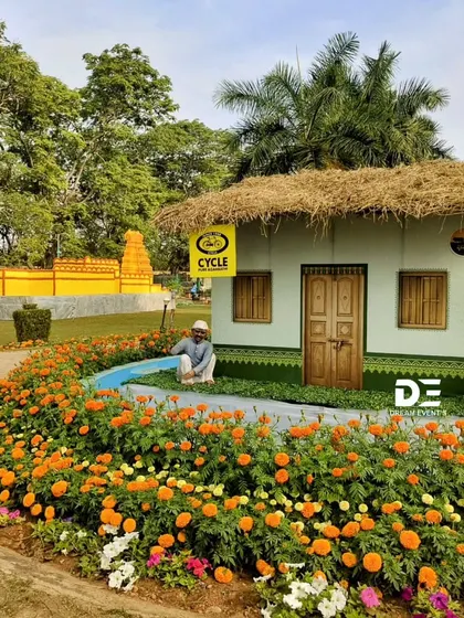 This installation recreates a rustic village scene, complete with a hut and figures, surrounded by a vibrant field of orange marigolds. It showcases my ability to tell a story and evoke a sense of place using landscape and floral design.