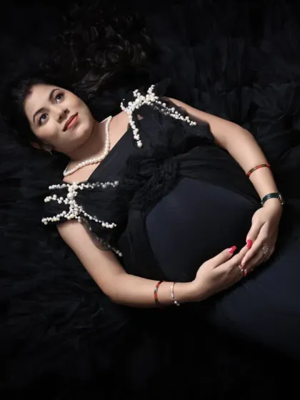 A beautiful top-down portrait of the mom-to-be. The pearl details on her black gown and her serene expression create a timeless and elegant image.