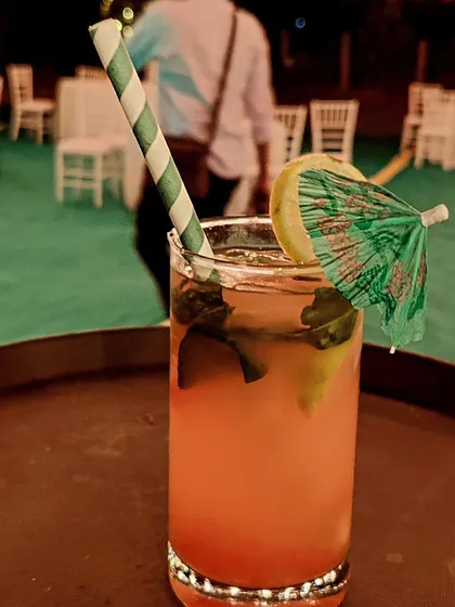 A refreshing pink mocktail served in a highball glass with a paper straw and a mini umbrella. We offer a full range of delicious non-alcoholic options so all guests can enjoy a special drink.