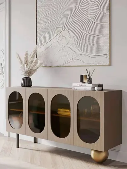 Another view of the Plisse cabinet, highlighting its unique spherical leg and the elegant oval glass windows.