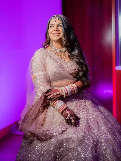 A happy and radiant bride, glowing under the lights. Her makeup is designed to look flawless and beautiful from every angle, all night long.