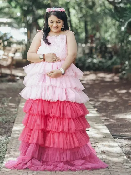 This mother-to-be is wearing our popular tri-color ombre gown with pink and red layers, a playful and eye-catching choice for an outdoor shoot.