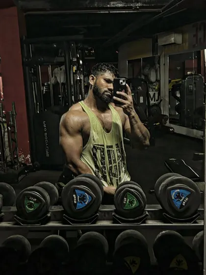 Another angle of the tricep pose. The lighting in the gym helps to highlight the muscle definition.
